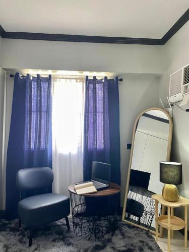 a room with a mirror and a desk with a laptop at Affordable 2BR Near Airport with WiFi, Netflix and Pool in Mactan