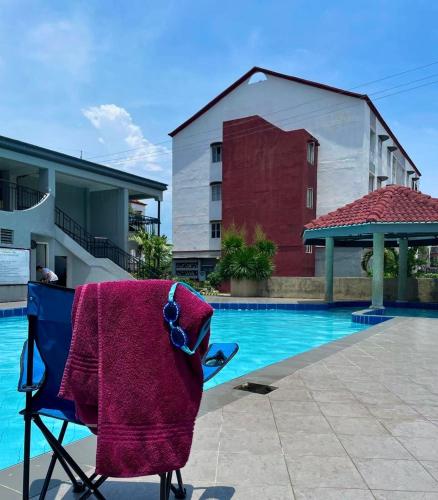 a towel sitting on a chair next to a swimming pool at Affordable 2BR Near Airport with WiFi, Netflix and Pool in Mactan