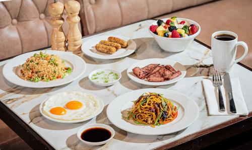 a table topped with plates of food on a table at Premier Inn Dubai Investments Park in Dubai