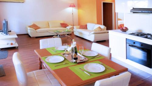 uma cozinha e sala de estar com mesa e cadeiras em Orange Bamboo Suite em Split