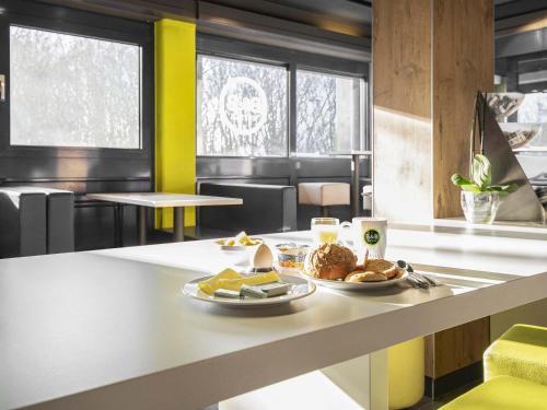 a breakfast table with a plate of food on it at B&B HOTEL Rostock-Broderstorf in Rostock