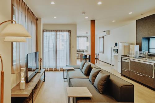a living room with a couch and a kitchen at Hazama in Tokyo