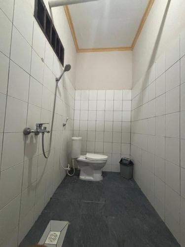 a bathroom with a toilet in a shower stall at Kuta Lodge Homestay in Kuta Lombok