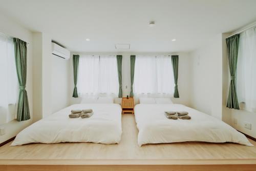 a bedroom with two beds with shoes on them at Hazama in Tokyo