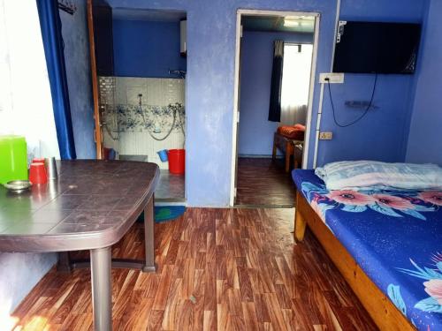 a small room with a table and a bed at Hams Cherrapunji in Cherrapunji
