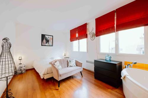 Un dormitorio con una cama, una silla y una bañera. en Granville centre - Duplex 6 pers, en Granville