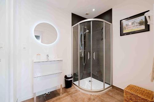 a white bathroom with a shower and a sink at Granville centre - Duplex 6 pers in Granville