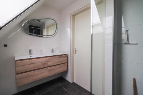 ein Badezimmer mit Waschbecken und Spiegel in der Unterkunft Beachvilla - 5 personen in Holle Poarte