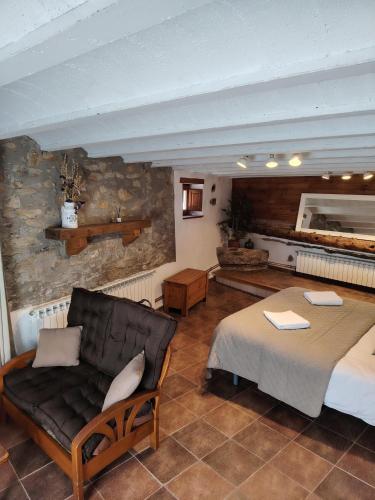 a bedroom with a bed and a couch in a room at Cal Tonico Rural in Ribes de Freser