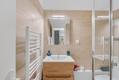 Un baño con lavabo y ducha con espejo. en Appartement Tout Confort, en Superdevoluy