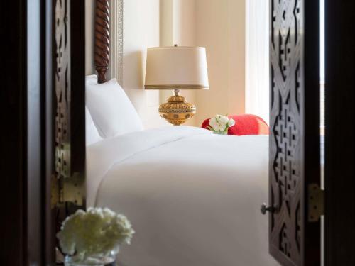a bedroom with a bed with a lamp and flowers at Sofitel Bahrain Zallaq Thalassa Sea & Spa in Manama