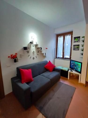 a living room with a couch and a clock on the wall at Apt tra arte e natura ingresso indipendente in Florence