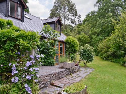 a house with a garden with purple flowers at Erw Goed Hen Feudy in Arthog
