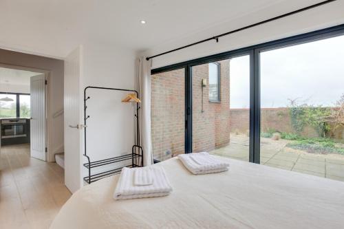 a bedroom with a bed and a large window at Two bedroom house with far-reaching country views in Sheering