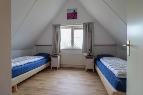 zwei Betten in einem Zimmer mit Fenster in der Unterkunft Beachvilla - 8 personen in Holle Poarte