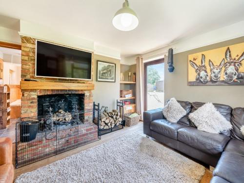 a living room with a couch and a fireplace at Egmont Farmhouse in Newenden