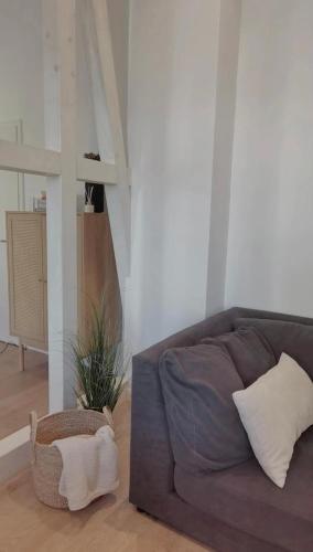 a living room with a couch and a plant at FeWo Großes 2 Zimmer Apartment in Berne in Berne