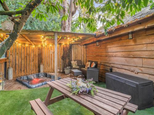 a wooden patio with a table and a hot tub at The Retreat - Uk50421 in Bisterne