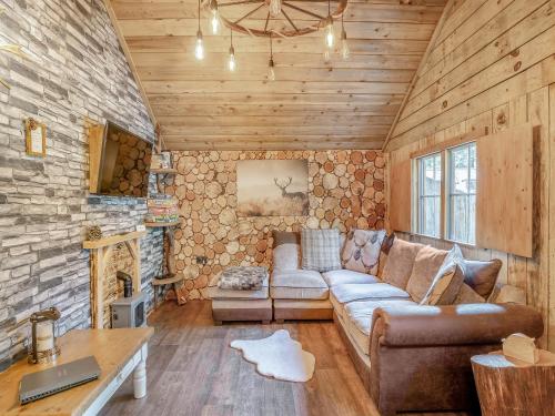 a living room with a couch and a stone wall at The Retreat - Uk50421 in Bisterne