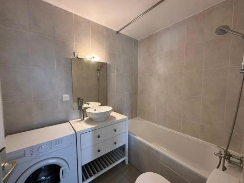 a bathroom with a sink and a washing machine at Lumineux F2 avec balcon confort et praticité in Mulhouse
