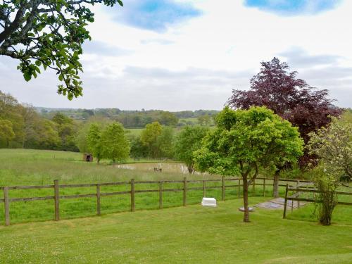 a bench in a field next to a fence at Oakwood Venbridge Farm in Cheriton Bishop