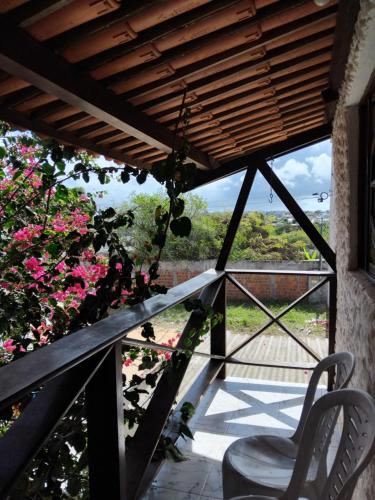 a balcony with a table and a chair and flowers at Falésias de Carapibus in Jacumã