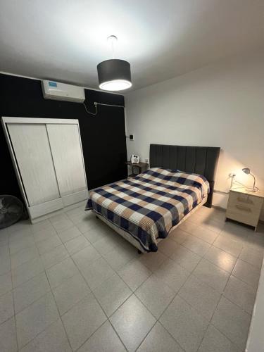 a bedroom with a bed with a checkered blanket at Samay2025 in La Rioja