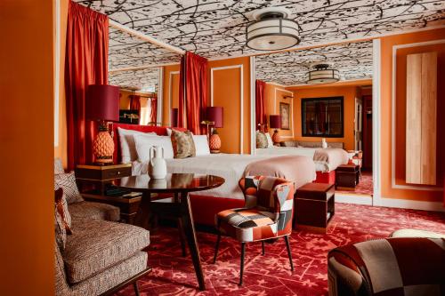 a bedroom with a bed and a table and chairs at House of Hütter- Münchner Kindl, Small Luxury Hotels of the World in Munich