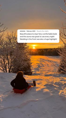 a person laying in the snow on a snowboard at Tennihovi Cottage Hosted by Hygge Host in Jokela