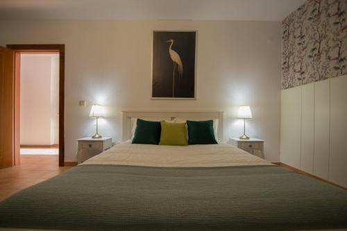 a bedroom with a large bed with two lamps at Casa dos Grous in Ponte de Lima