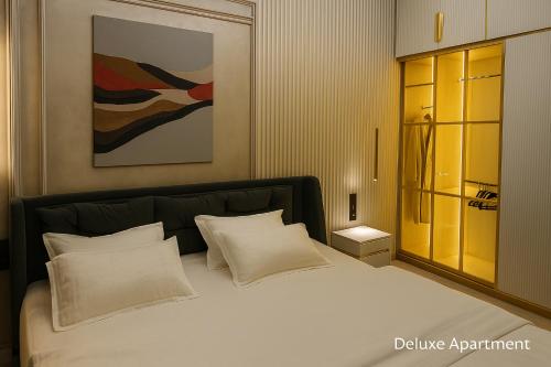 タシュケントにあるBoulevard - Apartment hotelsの白い枕が付いた大きなベッドのある寝室