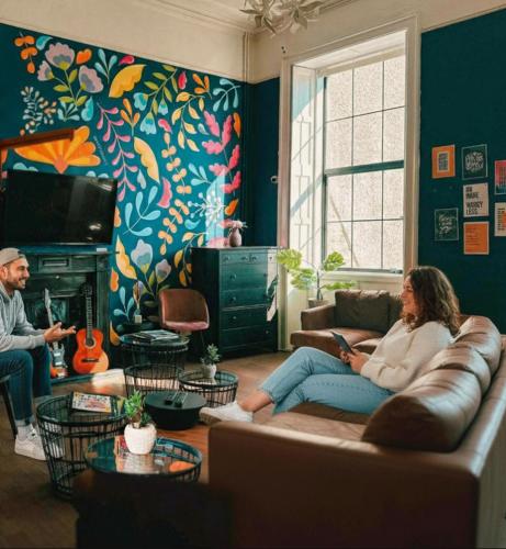 a woman sitting on a couch in a living room at Gardiner House Hostel in Dublin