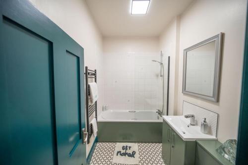 a bathroom with a tub and a sink and a bath tub at 2 Bed Newly refurbished apartment, Free Parking, Pet Friendly in Gloucester