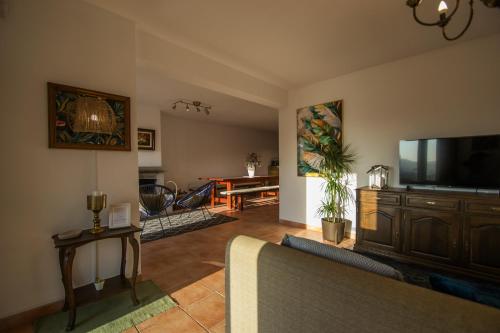 a living room with a couch and a flat screen tv at Casa dos Grous in Ponte de Lima