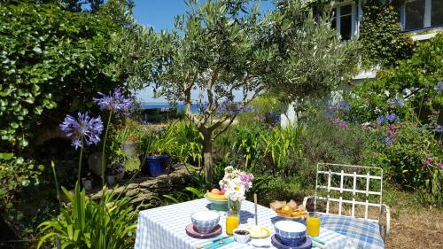 a table with a blue and white table cloth and flowers at L'écume de mer in Groix