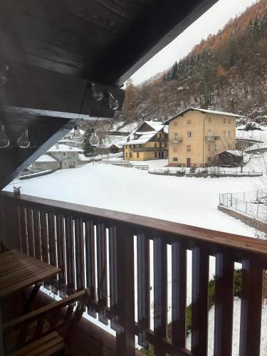 a view of a snow covered yard from a balcony at Val di Sole Apartment in Monclassico