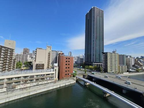 a bridge over a river in a city with buildings at R Home Sakuragawa Riverside in Osaka