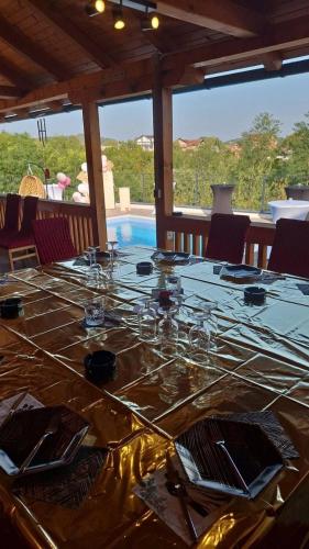a long table with wine glasses on top of it at Vikendica Elenda Banja Luka in Laktaši