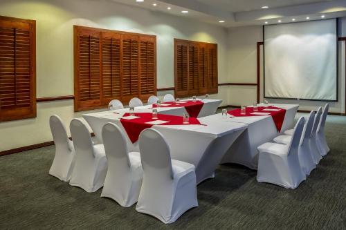 a conference room with white tables and white chairs at Fiesta Inn Ciudad Juarez in Ciudad Juárez