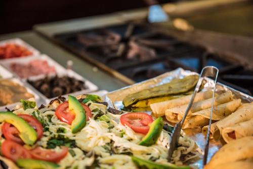 a tray of food with a pizza and vegetables on it at Fiesta Inn Oaxaca in Oaxaca City