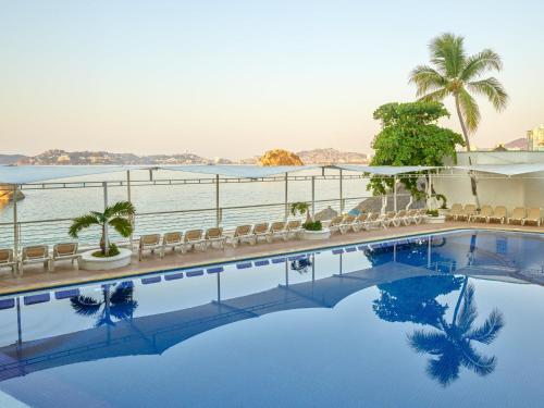 a hotel swimming pool with a view of the water at Fiesta Americana Acapulco Villas in Acapulco