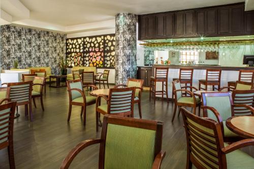 a restaurant with tables and chairs and a bar at Fiesta Inn Express Chihuahua in Chihuahua