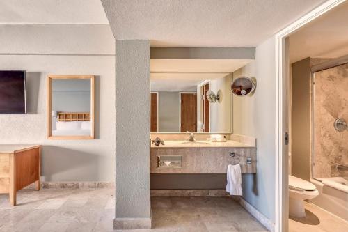a bathroom with a sink and a tub and a toilet at Fiesta Americana Acapulco Villas in Acapulco