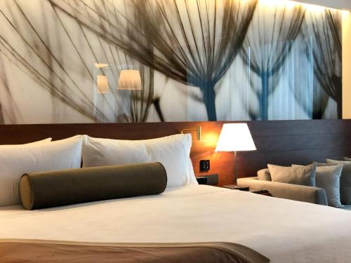 a bed in a hotel room with a painting on the wall at Live Aqua Cancun - Adults Only - All-Inclusive in Cancún