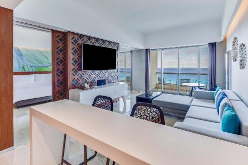 a living room with a couch and a tv at Live Aqua Cancun - Adults Only - All-Inclusive in Cancún