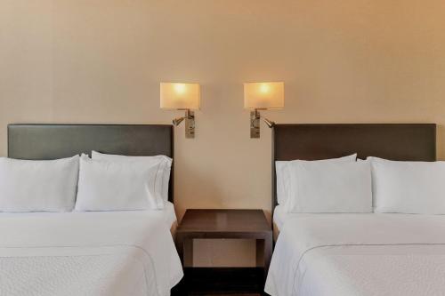 two beds sitting next to each other in a hotel room at Fiesta Inn Centro Historico in Mexico City