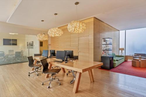 an office with a desk with two monitors and chairs at Fiesta Inn Centro Historico in Mexico City