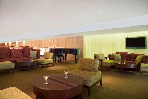 a living room with couches and a grand piano at Fiesta Americana Reforma in Mexico City