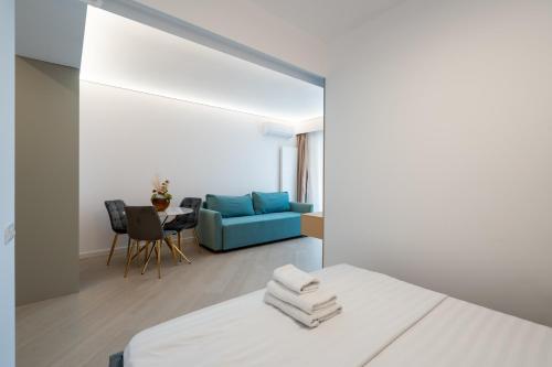 Zimmer mit einem Bett und einem blauen Sofa in der Unterkunft Studio Quattro Cortina North Stay in Voluntari