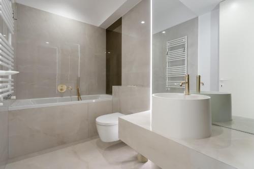 ein Badezimmer mit Toilette, Badewanne und Waschbecken in der Unterkunft Studio Quattro Cortina North Stay in Voluntari